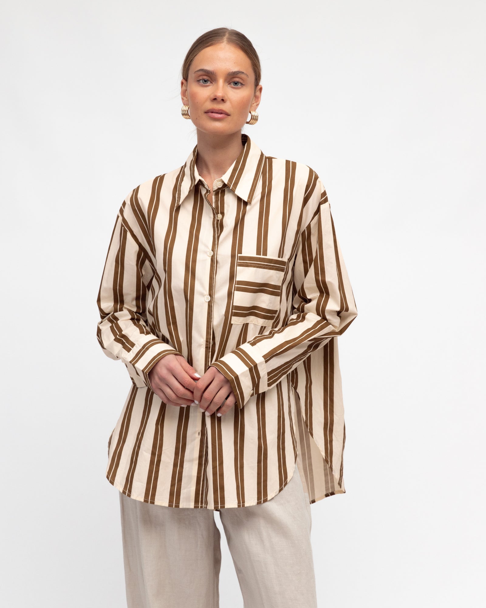 Woman wearing White Closet's long sleeve Francine Stripe Shirt in Cream and Brown.